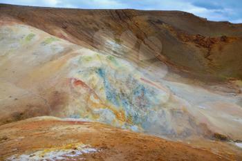 Unusual Iceland. Smoldering underground heat hillsides. In the hollows are last year's snow fields