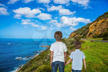 The concept of active tourism and recreation. Two boys standing  on Cape of Good Hope - the south-western point of Africa. Travel to South Africa