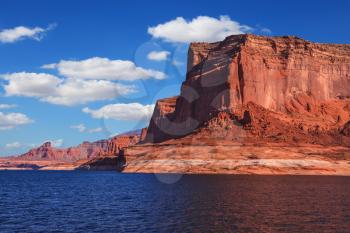  Lake Powell is surrounded by magnificent red hills. Scenic huge artificial water basin of the Colorado River, USA. Walk on the boat at sunset