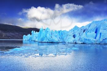 Chilean Patagonia. National Park Torres del Paine. Lake and Glacier Grey. A sharp wind and the cold sun over blue ice. Grey glacier moves down the water of the lake