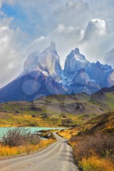 Summer day in the national park Torres del Paine, Patagonia, Chile. Cliffs of Los Kuernos among the clouds