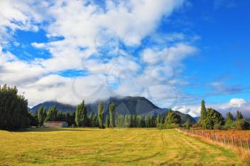 Countryside in Chilean Patagonia. Green fields and mountain range 