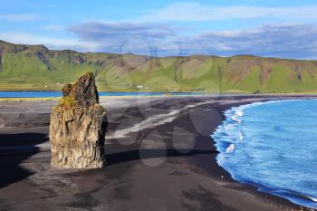 Cape Dirholaey in southern Iceland. On an ocean beach with volcanic sand is a huge rock
