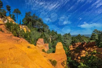  Multi-colored ocher outcrops - from yellow to orange-red. Green trees create a beautiful contrast with the ocher. Roussillon, Provence Red Village