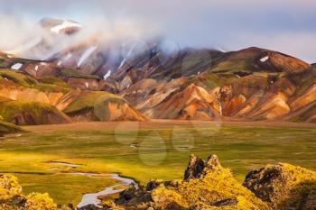 National Park Landmannalaugar, Iceland. Pink dawn in the Arctic. Striped mountains of rhyolite covered sunshine