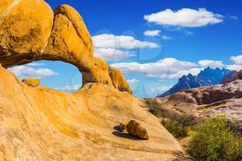 Stone arch of Spitzkoppe. Concept of extreme and ecological tourism. Natural group of smooth bald granites among the Namib Desert, Namibia