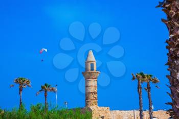 Palm tree, minaret and parachute.  National park Caesarea on the Mediterranean Sea