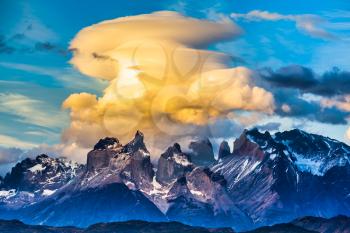 Magnificent cumulus clouds in the rays of the sunset. Torres del Paine National Park. Summer in the south of Chile. The concept of extreme and active tourism