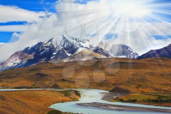 Beautiful summer morning in Patagonia.The river and the snow-capped mountains illuminated by the sun
