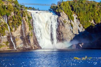 Montmorency Falls Park, close to the center of Old Quebec. Powerful waterfall Montmorency. Sunny autumn day. The concept of active and cultural tourism