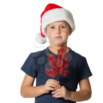 Boy in the red hat of Santa Claus posing with decoration for Christmas tree - maple leaf.  Photographed on a white background