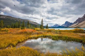 Canada, Rocky Mountains, Banff National Park. The smooth water reflects the cloudy sky. Snow-capped mountains and glaciers surroundings Bow Lake