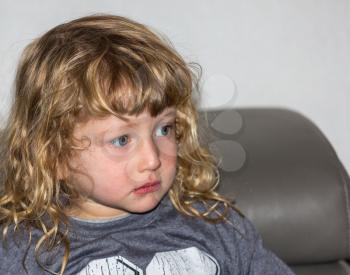 Beautiful little boy with golden curls and blue eyes