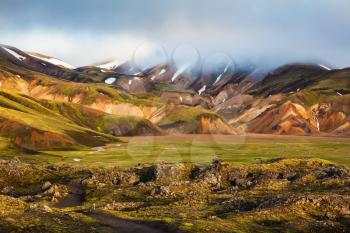 Pink dawn in the Arctic. Striped mountains of rhyolite covered sunshine.  National Park Landmannalaugar, Iceland
