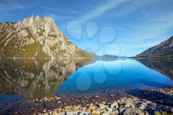 The concept of exotic and extreme tourism. The mirror water of the lake reflects sharp peaks and rocks. Pyramidal mountain in San Carlos de Bariloche