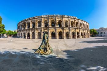  Monument to bullfighter installed before the arena. Roman amphitheater in Nimes, Provence. Photo taken fisheye lens
