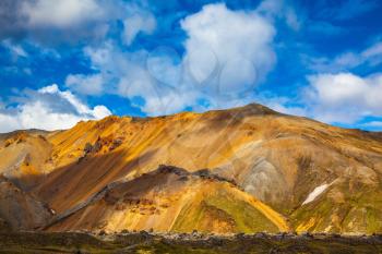  Volcanic summer tundra.  Bright and multi-colored rhyolite mountains - orange, yellow, green and blue. Travel to Iceland in July