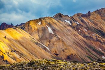 Multi-color rhyolitic mountains are lit with the July sun. National park Landmannalaugar. Travel to Iceland in the summer