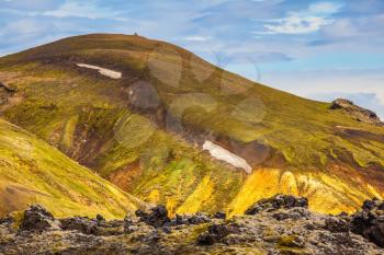 Incredible shades of rhyolitic mountains - yellow, orange, green and blue. Summer volcanic tundra.  Travel to Iceland in July