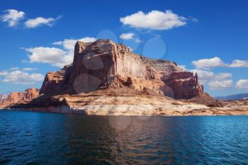 The lake is surrounded by picturesque banks of red sandstone. Scenic huge artificial lake Powell on the Colorado River, USA. Walk on the boat at sunset