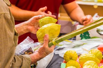 Customers choose citrus - etrog and lulav. Ancient Jewish autumn holiday Sukkot. Sale of ritual plants on the traditional pre-holiday market in the capital of Israel, Jerusalem