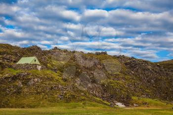Summer trip to Iceland. The green lawn in the Valley National Park Landmannalaugar. Tourist house lava slope