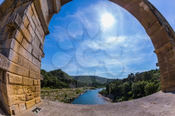 Part of the bridge. One bridge span is photographed lens Fisheye. Three-tiered aqueduct Pont du Gard - the highest in Europe. Provence, spring sunny day