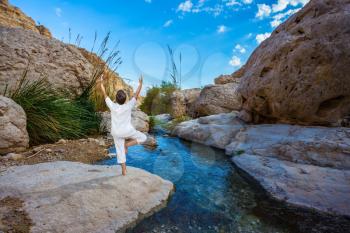  Travel national parks and reserves Ein Gedi, Dead Sea, Israel. Elderly woman practices yoga on small lake