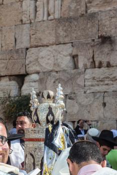 JERUSALEM, ISRAEL - OCTOBER 12, 2014: Morning autumn Sukkot. The area in front of Western Wall of  Temple. Crowd of Jewish worshipers in white wearing prayer shawls. On table there is Torah Roll in magnificent case
