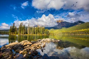 Transparent autumn morning in Jasper National Park, Canada. The woody small island in Pyramid Lake