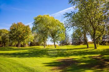  Golf Club in Canada. Green grass golf course is surrounded by scenic autumn park. Concept of Golf tourism