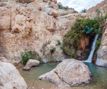  The journey through the reserves Ein Gedi. Adorable waterfall among rocks parched desert