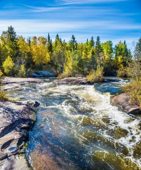 Warm autumn day. Foam water rapids on the smooth stones of the Winnipeg River. Old Pinawa Dam Provincial Heritage Park. The concept of ecological and adventure tourism