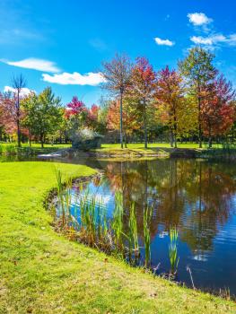  Park of fantastic beauty. Golf Club on the road to Bromont, French Canada. Concept of Golf tourism. Red, orange and green autumn foliage is reflected to clear water of the lake