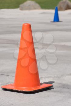 Royalty Free Photo of an Orange Traffic Cone With a Blue One in the Background