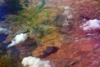Dramatic aerial view from plane of  patchwork farmland and houses 