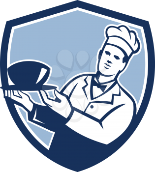 Illustration of a chef cook holding bowl serving set inside shield crest on isolated background done in retro style. 
