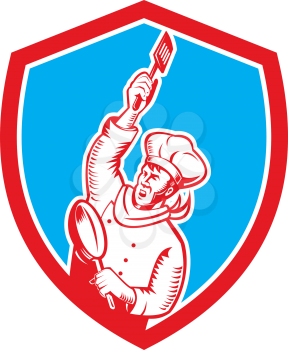 Illustration of a chef cook baker holding spatula and frying pan set inside shield crest done in retro woodcut style on isolated background. 