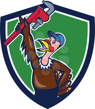 Illustration of a turkey plumber looking up raising monkey adjustable wrench set inside shield crest on isolated background done in cartoon style. 