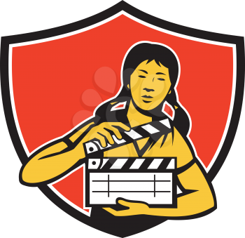 Illustration of an asian woman movie clapper holding clapboard viewed from front set inside shield crest on isolated background done in retro style. 