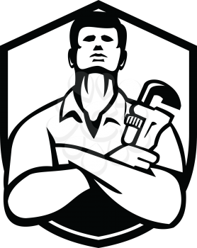 Black and White Illustration of a handyman plumber repairman worker arms folded holding monkey wrench set inside badge shield crest on isolated background done in retro style.