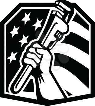 Illustration of an American plumber hand clutching adjustable pipe wrench or monkey wrench viewed from the side set inside shield crest with usa stars and stripes flag in the background done in retro style. 