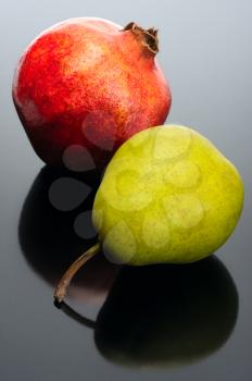 Royalty Free Photo of a Pomegranate and Pear on Black