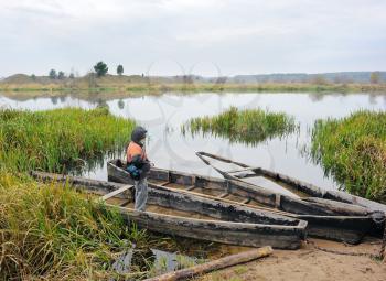 Royalty Free Photo of a Boy With Boats at a River