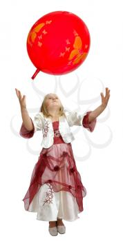 Girl in a smart dress plays with a red balloon.