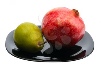 Pomegranate and pear on a black platte, isolated.