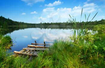 Royalty Free Photo of a Lake With Long Grass Around It and a Wooden Dock