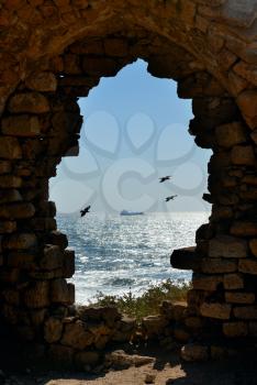 Royalty Free Photo of a Sea View Through the Door of a Ruined House