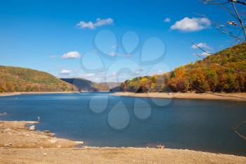 Royalty Free Photo of a Placid River Surrounded by Mountains in Autumn