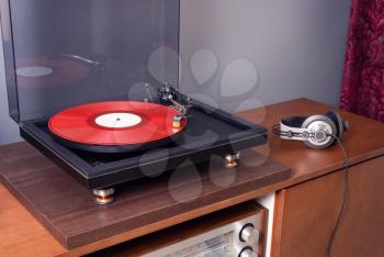 Vintage Stereo Turntable Plays Red Vinyl Record Album, angled view